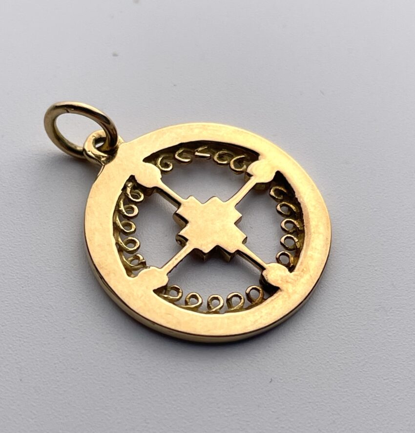 Médaille en or à décor d'une croix centrale et de volutes